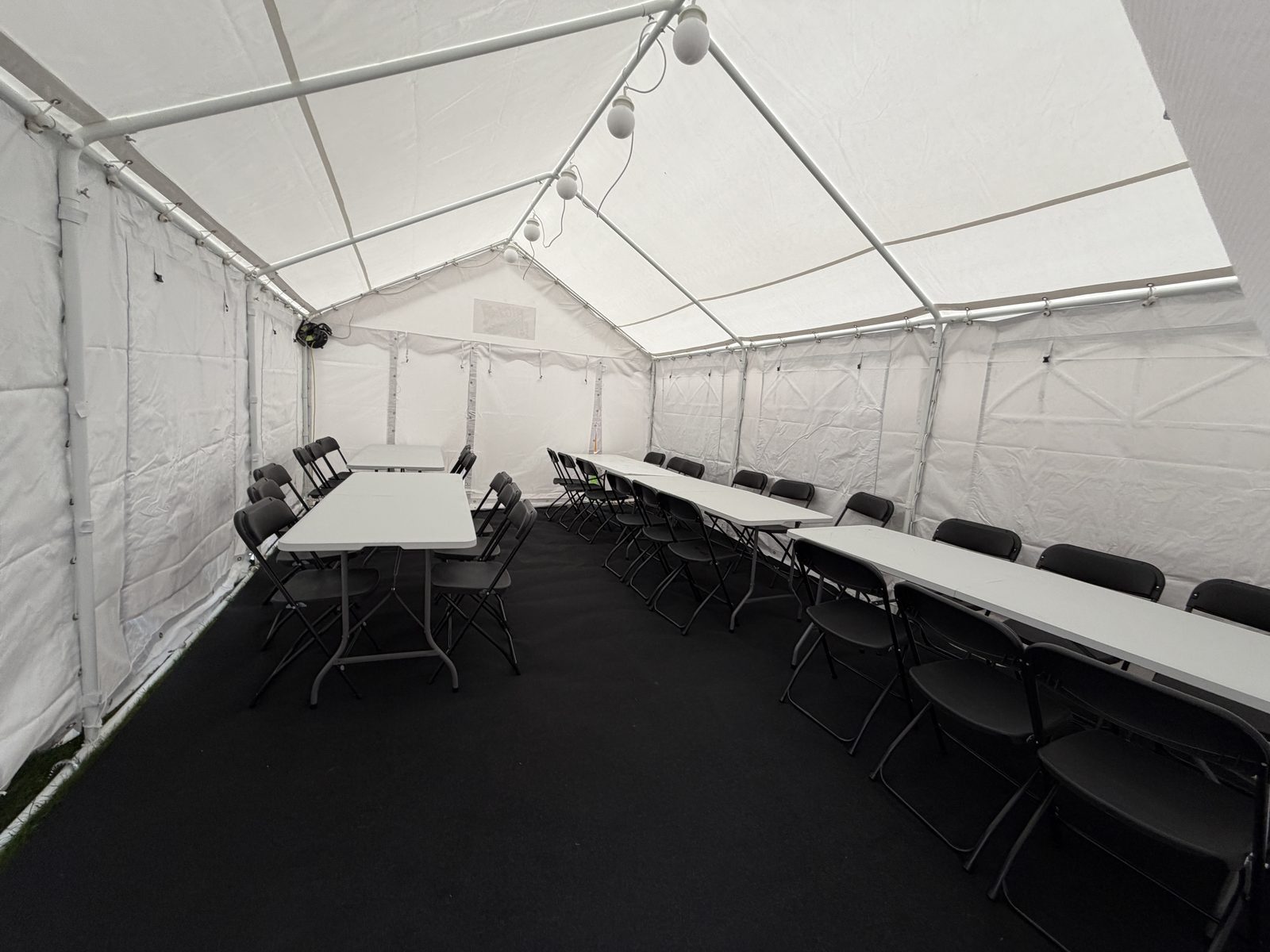 Long rows of tables and chairs running the length of the marquee interior