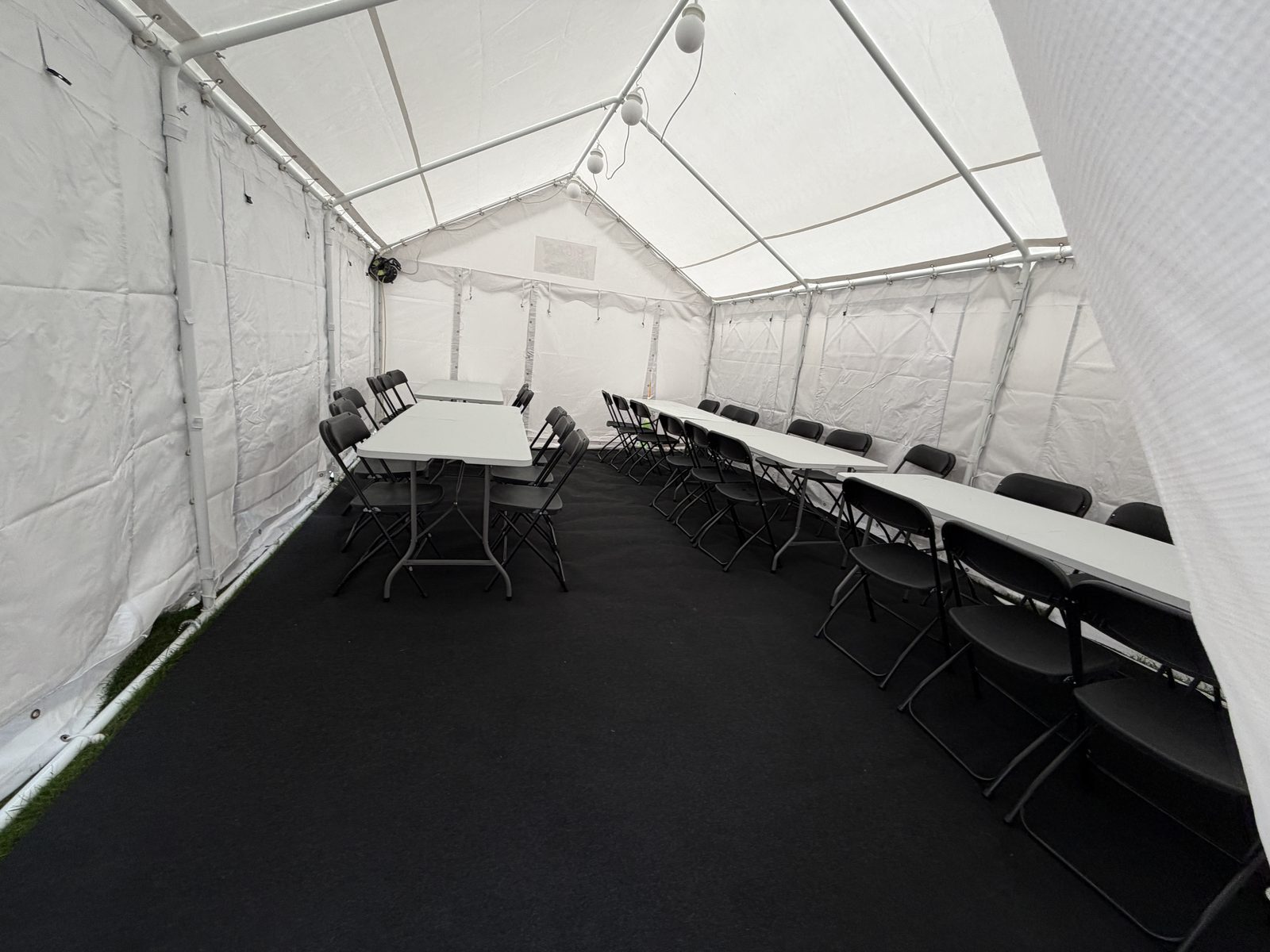 Tables and folding chairs lined up inside the marquee ready for guests